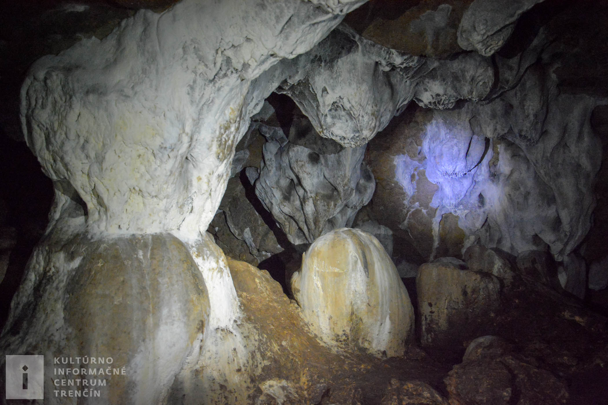 Snehobiela farba sintrového povrchu kontrastuje s tmavým dnom jaskyne, ktoré je na mnohých miestach pokryté vrstvami guána – netopierieho trusu.